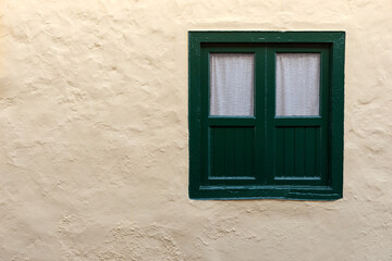 Characteristic green window on a yellow house wall. Tenerife, Canary Islands, Spain