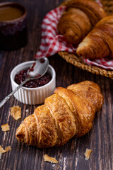 Freshly browned croissant placed on a metal plate and glass with sweets