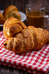 Freshly browned croissant on kitchen towel and coffee