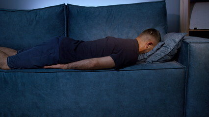 Tired boy slumping on couch feeling listless. Media. Feeling depressed, lack of motivation,...