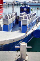 Bollard on the pier against the background of a motor boat and y