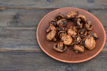 a portion of mushrooms champignons in a plate. on a wooden rustic table.