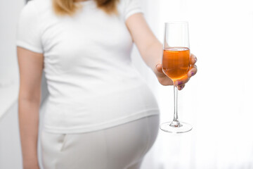 Pregnant woman offers glass of wine. 
