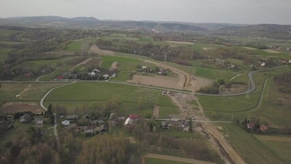 Laying gas pipeline among green hills. Large high-pressure steel pipes prepared for immersion in...