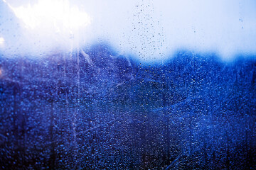 pattern of small raindrops against a clear blue toned surface