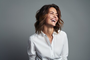 Fototapeta na wymiar Woman with joyful laughter in a classic white blouse, ideal for corporate wellness and positive work environment imagery.