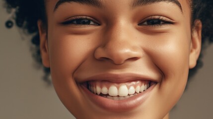 Obraz premium Smiling teen against a clear background, highlighting perfect teeth.