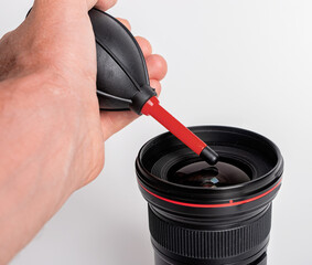 Dust blower in hand for camera lens cleaning, dust removing