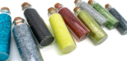 Assortment of glass vials filled with glitter for DIY projects or kids school arts and crafts drawings