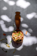 dry chopped vegetables carrot, parsley, dill, onion, celery in a wooden spoon, white background, sunlight, no people, minimalism, close-up