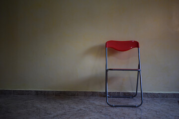  raw non edited photo  metal folding chair against yellow wall, empty room, tiled floor, simple...
