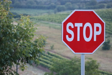 Stop road sign on the background of vineyards and farmland