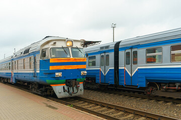 The locomotive is moving by rail. A passenger train goes to the railway station, transporting...