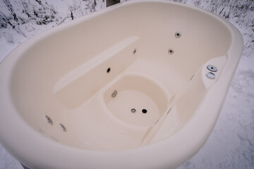 Open air hot bath outdoors in winter. Iron tub for bathing