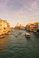 Obraz premium grand canal old city in venice italy with many boats, gondolas and italian palaces santa maria della salute basilica church in background