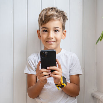One small caucasian boy hold mobile phone smartphone take photos