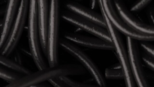 Black cooked boiled pasta, rotation in circle. cooked cuttlefish ink black pasta Turning. selective focus. Vertical video