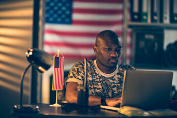 Focused Soldier Working on Laptop at Military Base