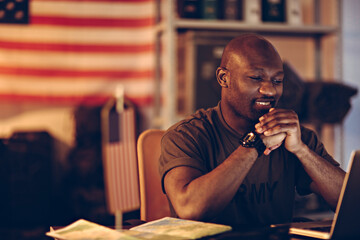 Focused Soldier Working on Laptop at Military Base