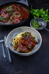 Traditionelles geschmortes italienisches Ossobuco alla Milanese mit Gremolata und Spätzle serviert in einer Nordic Design Schale