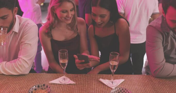 Party, cellphone and girl friends with champagne at a luxury, elegant and classy celebration or event. Smile, phone and young women talking with a glass of sparkling wine at nightclub together.