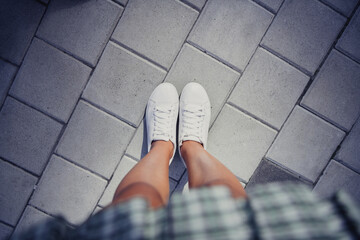 High angle view cropped close up portrait of girl legs new white sneakers pastime walking street...