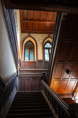 Fragment of an interior with an old beautiful wooden staircase and gothic windows in the Sharovsky castle, Ukraine