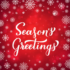 Fototapeta na wymiar Seasons Greetings calligraphy hand lettering on red background with bokeh and snowflakes. Merry Christmas and Happy New Year celebration poster. Vector template for greeting card, banner, flyer, etc.