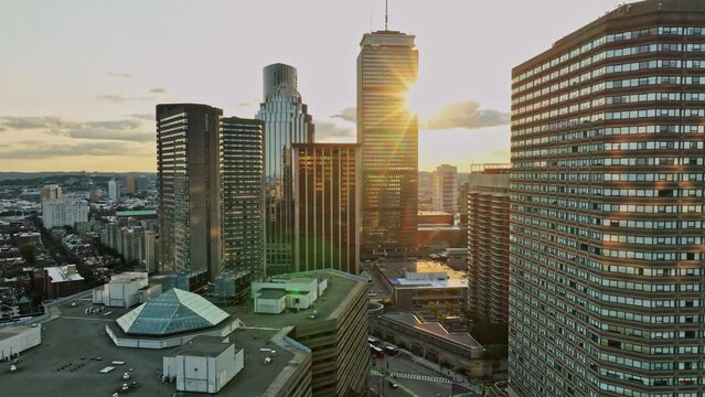 The sun is setting over a city with tall buildings