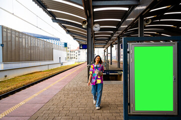 Beautiful happy woman on railway station. Mock-up billboard or vertical poster.