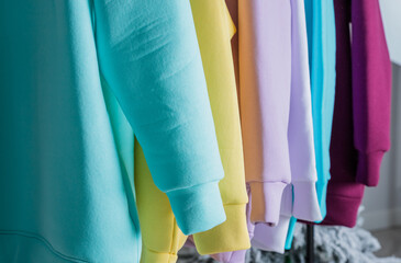 Sweatshirts on hangers in the clothing store for sale. Row of colorful cashmere hoodies for youth. Multi-colored sweatshirts in a clothes stand in the mall.fashion woman's sweats hoodie