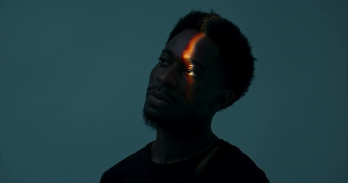 Abstract concept. African american dark skinned man in studio with bright light isolated handsome attractive male .