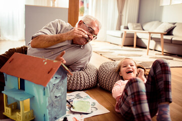 Grandfather and Granddaughter Enjoying Playtime with a Toy House