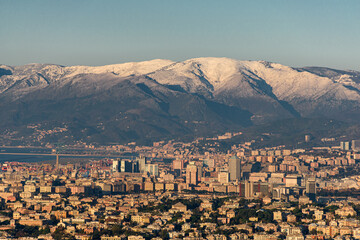 Panoramic winter view of Genoa with surrounding mountains in the background