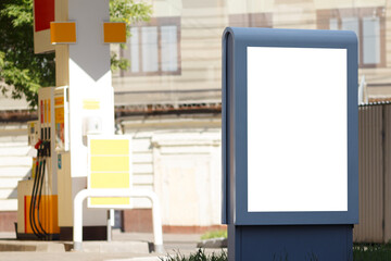 Vertical billboard next to a gas station. Mock-up.