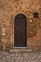 Fototapeta na wymiar Ancient wooden door in brick wall.