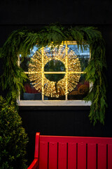 Modern Christmas wreath made out of gold fairy lights hanging in a window and framed with cedar...