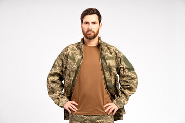 Handsome bearded man, soldier wearing camouflage military uniform holding looking at camera isolated on white background