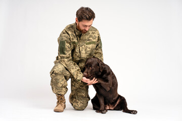 Handsome bearded man, soldier training Labrador dog isolated on white background 