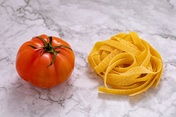 Pasta tagliatelle and tomato seen from above