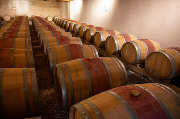 French oak wooden barrels for aging red wine in cellar, Saint-Emilion wine making region picking,...