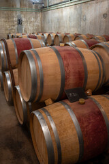 French oak wooden barrels for aging red wine in underground cellar, Saint-Emilion wine making...