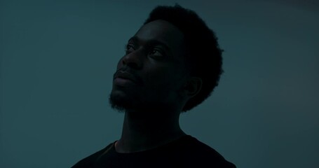 Abstract concept. African american dark skinned man in studio with bright light isolated handsome attractive male.