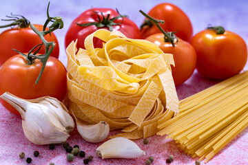 Spaghetti with tomato garlic and tagliatelle isolated on gray background
