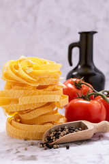 Tagliatelle pasta, tomatoes and peppercorns placed in a wooden box