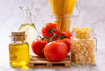 Fresh tomatoes, raw spaghetti and oil