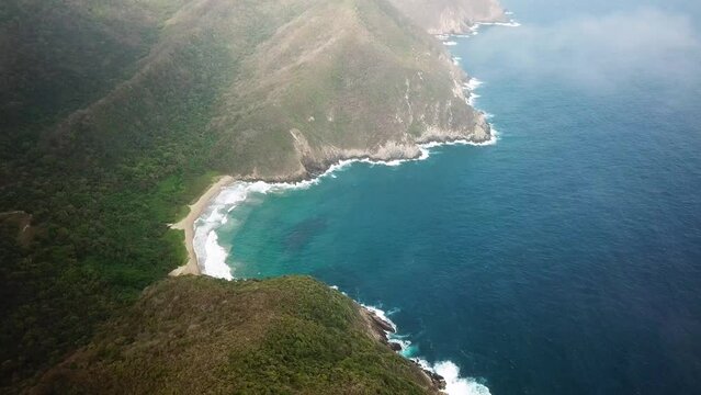 Aerial drone footage of the deep paradise nature in Tayrona National Park, Colombia, Latin America. Turquoise sand beach and white rocks of Caribbean coast. High quality 4k footage.