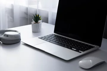 Fotobehang Laptop computer keyboard mouse and music earphones on a white table background © yursavieno