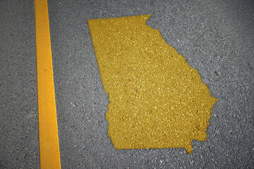 yellow map of georgia state on asphalt road near yellow line.