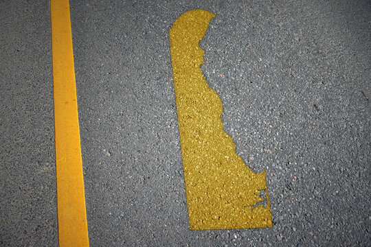 yellow map of delaware state on asphalt road near yellow line.